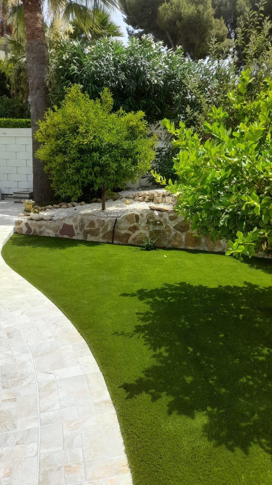 Curved garden path with artificial grass and stone border Costa Blanca