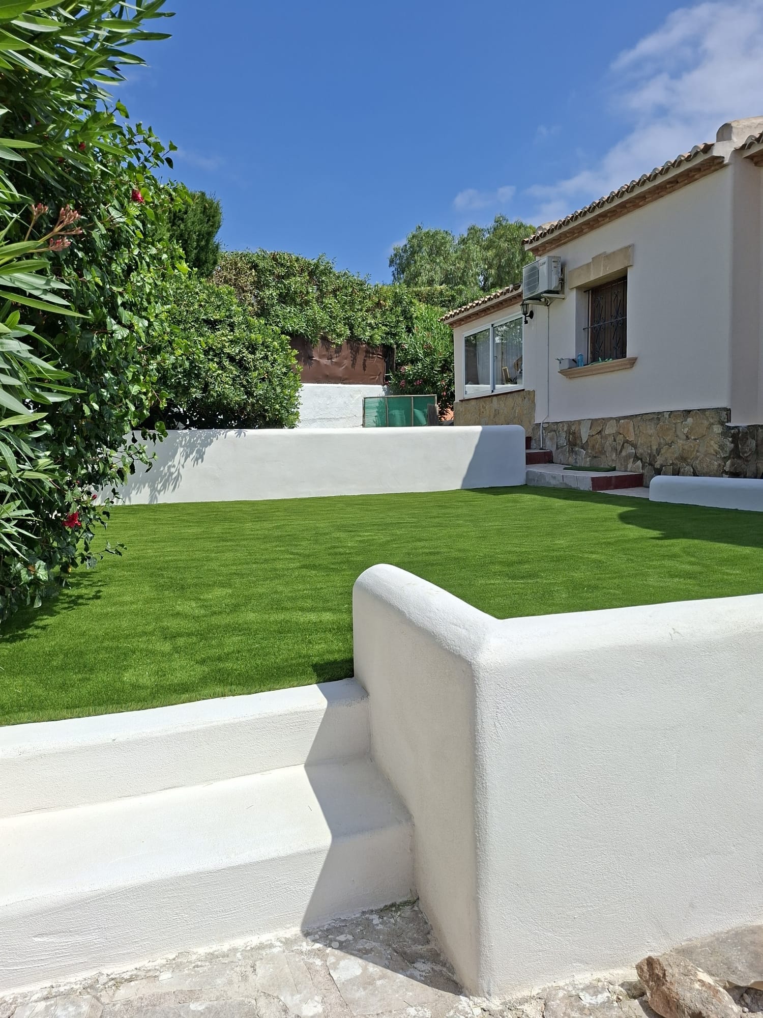 White walled villa garden with artificial grass Spain