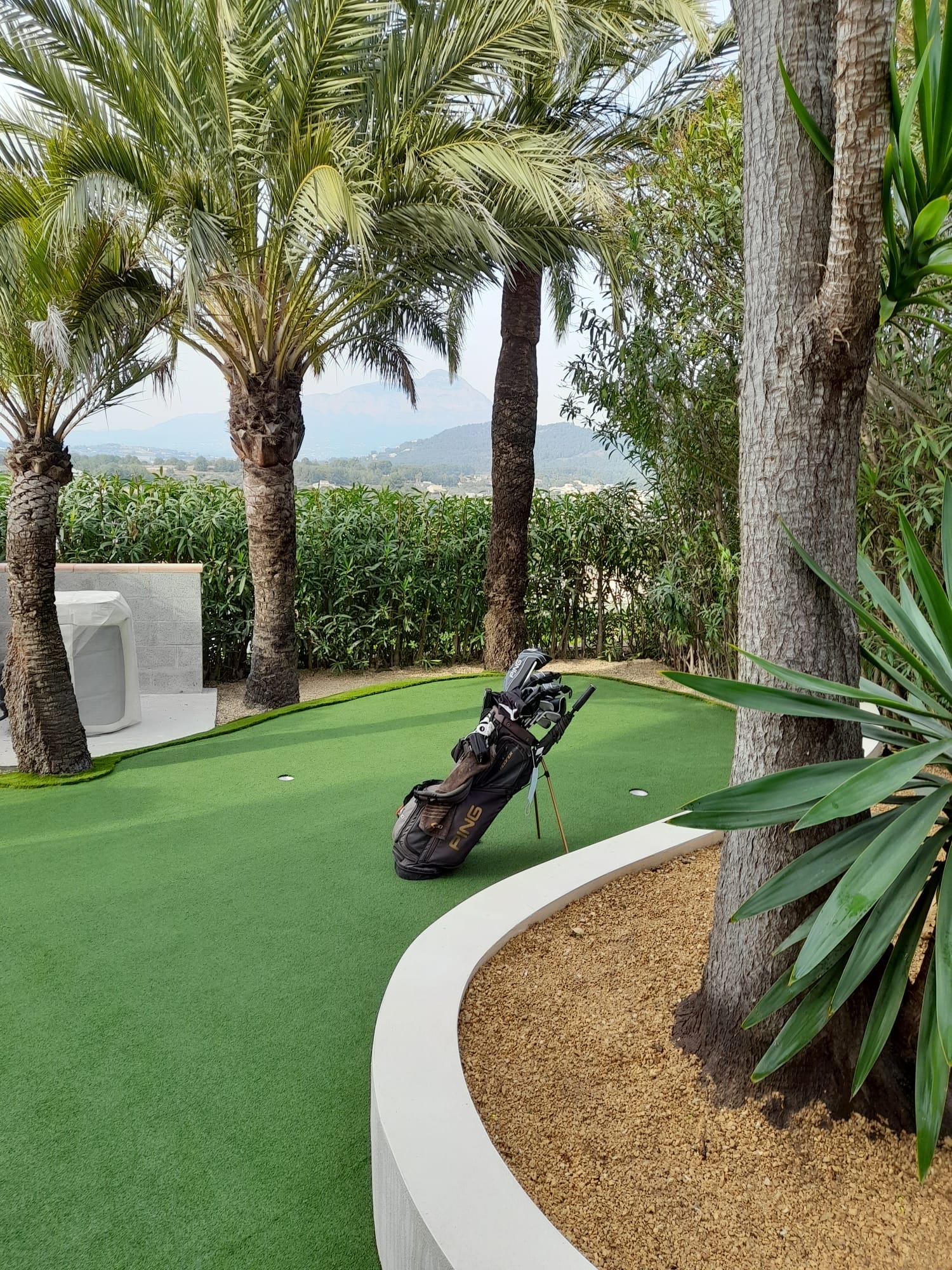 Mini golf course with tropical landscaping palm trees and mountain views Spain