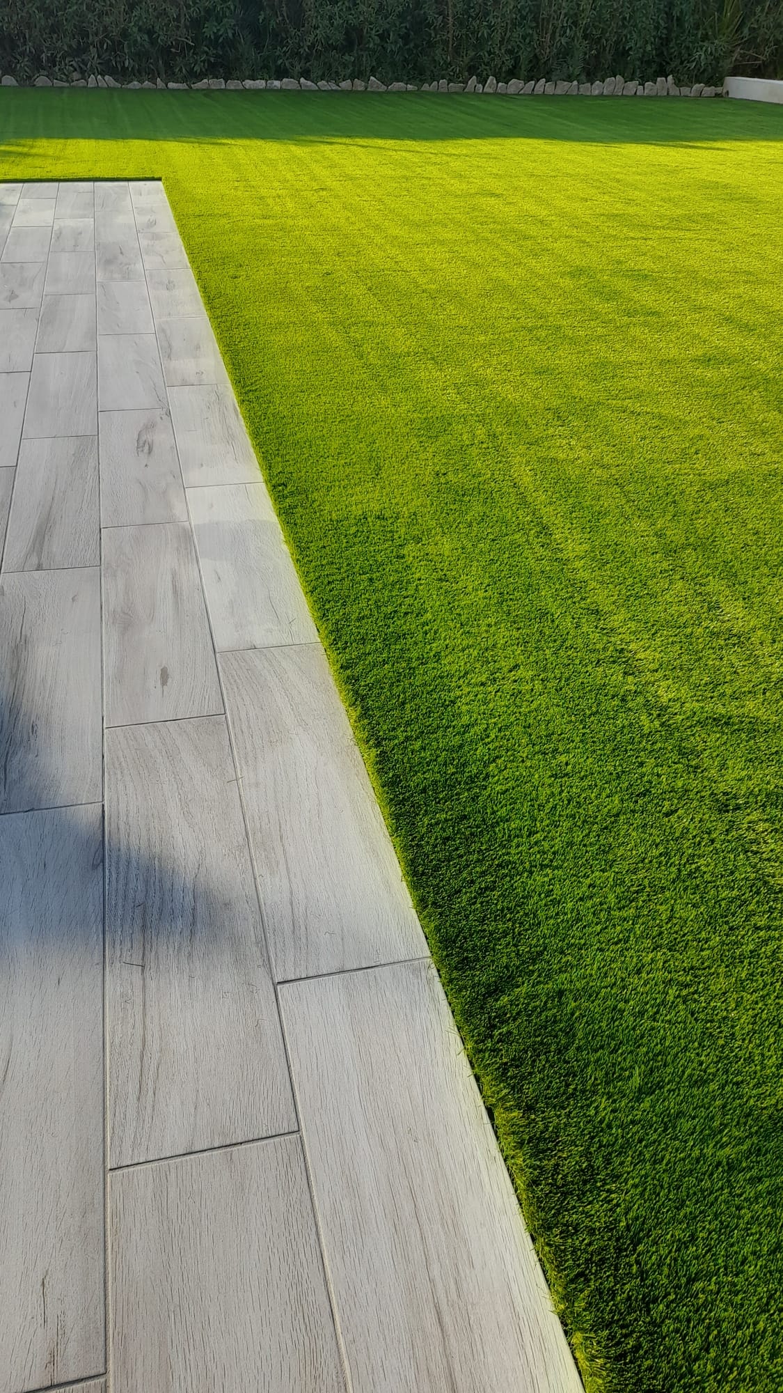 Artificial grass edge detail with porcelain tile terrace Spain