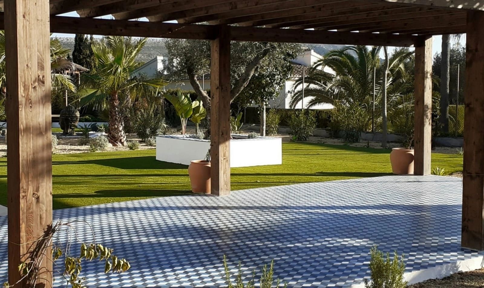 Large garden with artificial grass pergola and palm trees Spain