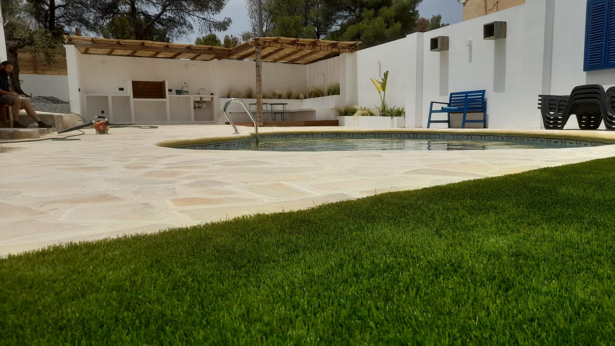 Artificial grass pool area with wooden pergola Spain